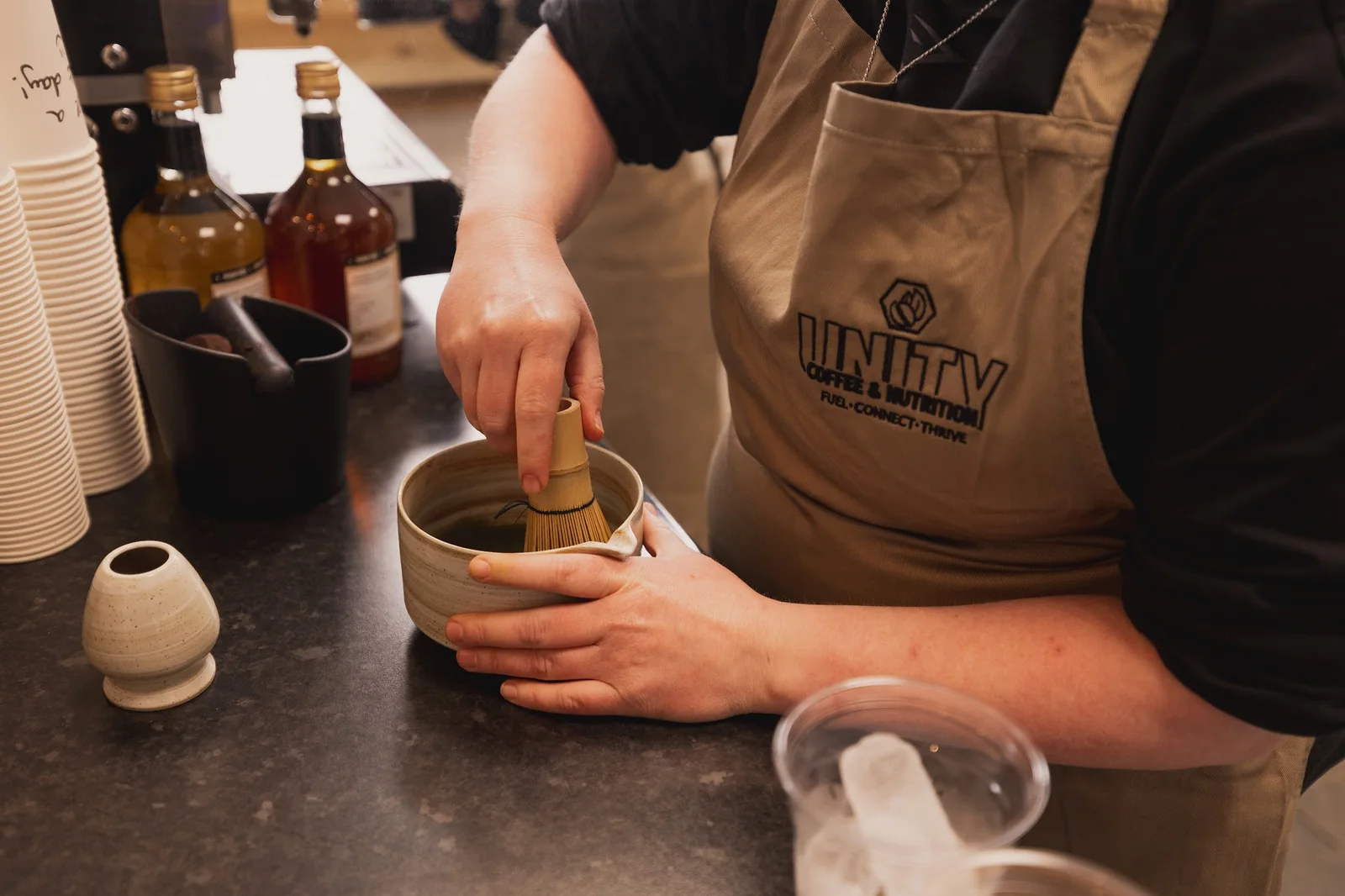 A Unity team member whisking matcha behind the counter
